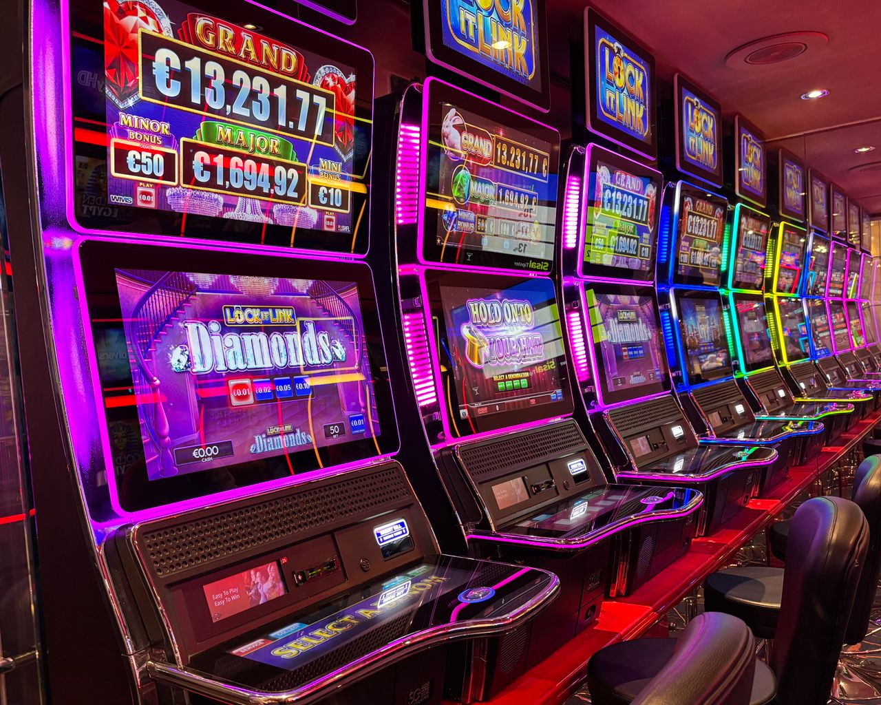 Crafting Captivating Headlines: Your awesome post title goes here Colorful slot machines lined up in a casino with neon lights and jackpot displays.